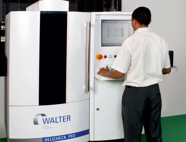 Engineer operating a Walter Helicheck Pro tool measuring machine.